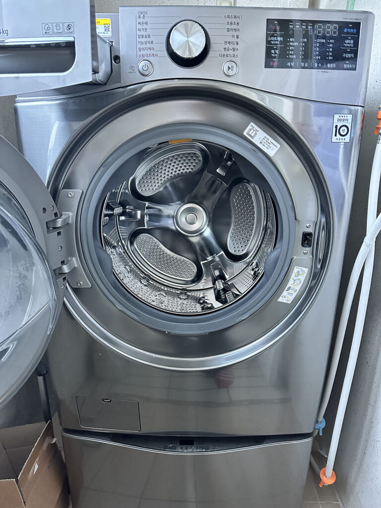 문을 연 드럼세탁기 내부를 보여주는 청소 관리 사진